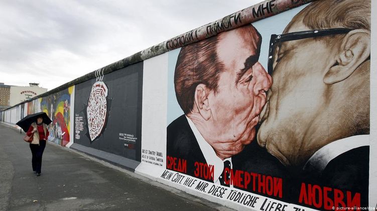 Часть Берлинской стены сохранили как память и изрисовали граффити, на одном из которых изображены целующиеся Брежнев и лидер ГДР Хоннекер 