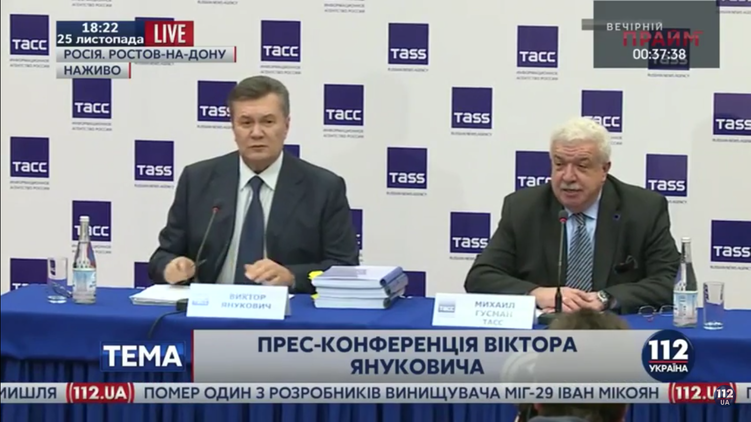 Виктор Янукович, которому помогает Михаил Гусман, отвечает на вопросы журналистов, фото: 112.ua