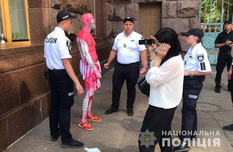 Мужчина облил краской не только постамент с флагом, но и себя. Скриншот из фейсбука полиции Киева