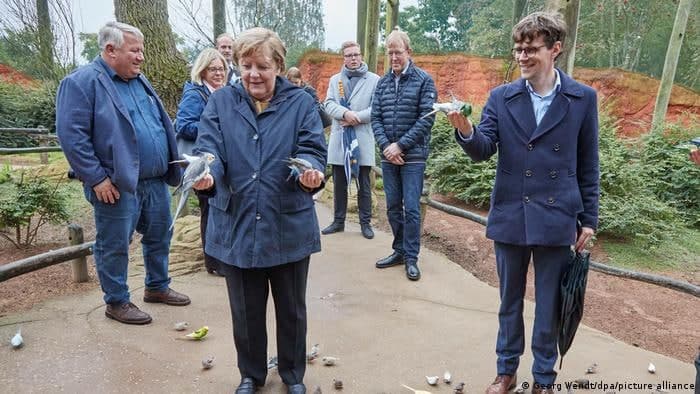 Меркель сфотографировалась с попугаями. Фото: DW